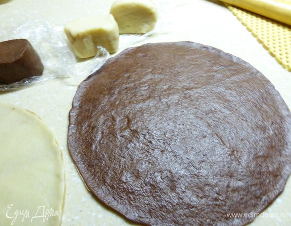 Из каждой половины надо выпечь по 3 коржа. Я по диаметру блюда из пекарской бумаги вырезала два трафарета и прямо на этих листах раскатывала тесто, помогая себе, если нужно, руками.  