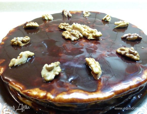 Готовые коржи обильно смазываем сметанным кремом. Нижний корж должен быть темным, последний белый корж покрываем остывшей глазурью. Сверху торт украшаем орехами и ставим настояться в холодильник, как правило, на ночь.