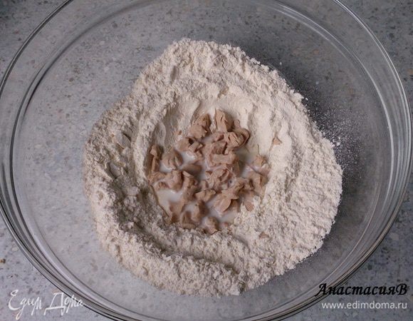 Муку просеять в чашу, сделать посредине углубление, раскрошить в него дрожжи, залить небольшим количеством теплого молока и, накрыв, дать подойти в течение 20 минут в теплом месте.