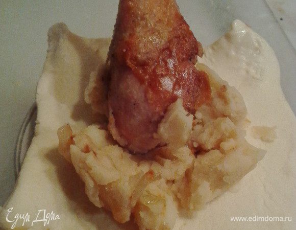 Мягкое тесто делим на квадраты 15x15 см. В центр каждого кладем 1 столовую ложку с горкой картофельного пюре. Сверху на него ставим ножку косточкой вверх. Уголки теста поднимаем и защипываем по бокам между собой и прижимаем плотно к косточке. Для уверенности (по желанию) можно зафиксировать ниткой, как бы завязывая мешочек. Даём минут 20 на расстойку.