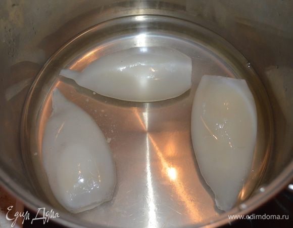 Отварив размороженные кальмары (3-4 мин в подсоленной, кипящей воде).