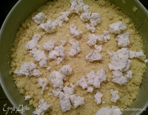 В смазанную форму (у меня была форма диаметром 24) крошим руками 2/3 теста, сверху крошим творог.