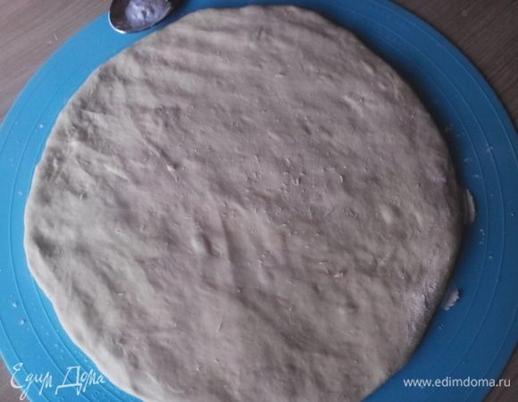 Далее лучше руками растянуть тесто на столе, примерно толщиной в 2 см. Если раскатывать тесто скалкой, придётся подсыпать муку, а это лишнее.  Чайную ложку соды разделить на три части. Одну часть соды распределить равномерно по всей поверхности теста. Свернуть тесто конвертом.