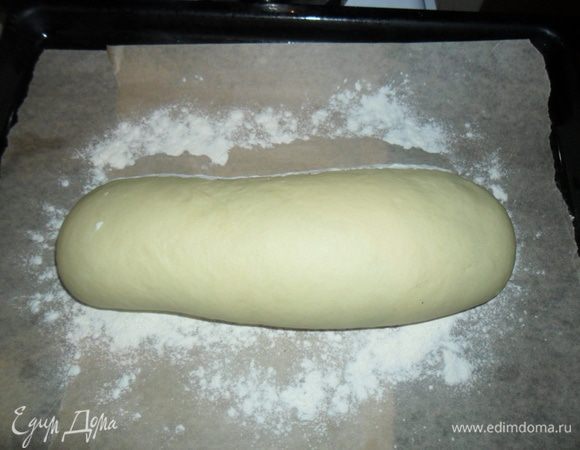 Когда тесто подошло, еще раз вымешиваем и формируем батон. Выкладываем на противень застланный пергаментом и присыпанный мукой. Присыпаем батон мукой и даем подойти 45 минут - 1 час.