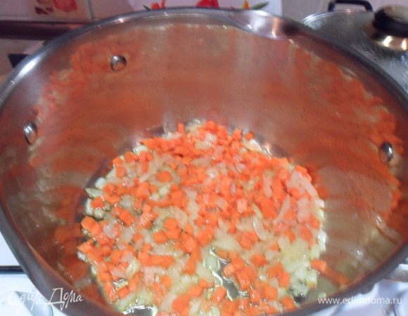 В кастрюле разогреем растительное масло и обжарим мелко нарезанный лук и нарезанную морковь.