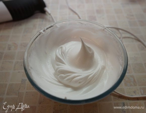 Включить разогреваться духовку до 200 градусов. Противень застелить пергаментом. 
Взбить белки с оставшимся сахаром. Для этого в самом начале взбивания добавить щепотку соли в белки и сначала на маленькой скорости до появления пены, затем на средней скорости взбивать до мягких пиков. Не прекращая взбивать постепенно по чайной ложке добавить сахар и взбивать до жестких пиков.