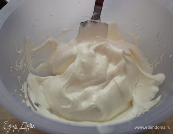 Аккуратно порциями ввести белки в желтковую массу, движениями лопатки снизу вверх.