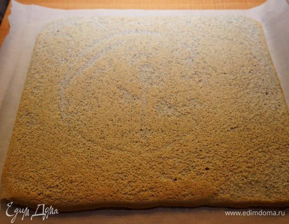 На столе расстелить полотенце или бумагу для выпечки. Перевернуть на неё корж. Снять пергамент, на котором выпекалось тесто.