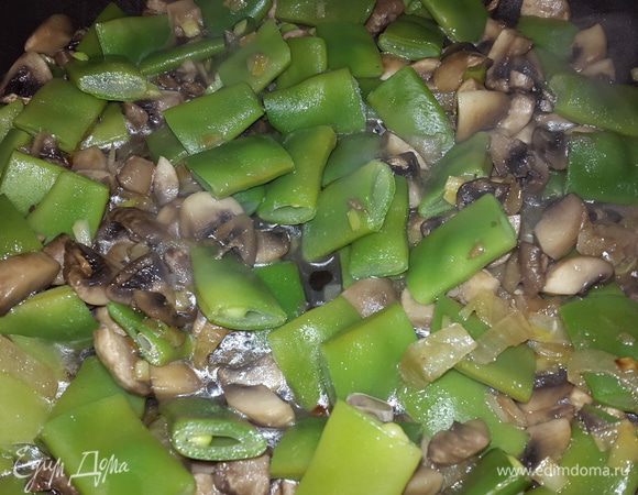 Добавляем фасоль к луку и грибам, перемешиваем и тушим на медленном огне примерно 5-7 минут.
