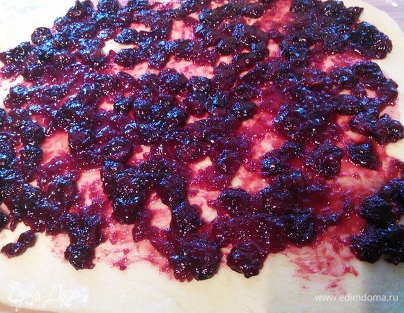 Тесто раскатайте в квадрат. Выложите вишнёвый мармелад, сбрызните несколькими каплями вишнёвого ликёра или другим алкоголем. Сверните в рулет и положите в форму для запекания, предварительно смазанную маслом и посыпанную сухарями. 