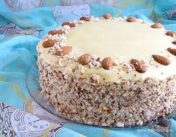Сверху аккуратно вылить на торт еще теплую глазурь. Кулинарной лопаткой разровнять поверхность. Бока торта обсыпать миндальной крошкой, по желанию. Украсить торт орешками. Убрать в холодильник для охлаждения часа на два.