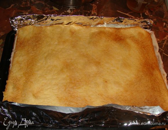 Коржи уложить в форму. У меня прямоугольный торт, поэтому я нарастила края противня для выпечки фольгой. Каждый корж смазываем 3-4 ст.л. крема. Верхний корж не смазываем пока, оставим для него 4 ст л. крема. Торт оставим пропитаться около часа при комнатной температуре, затем уберем в холодильник на ночь.