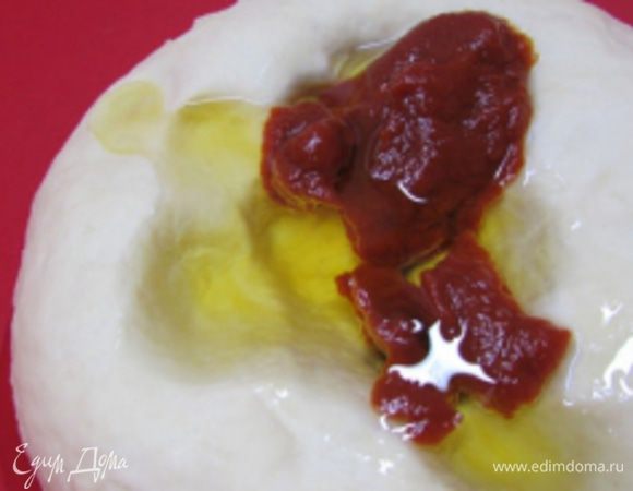 Добавить оливковое масло и томатную пасту. Вымесить тесто.