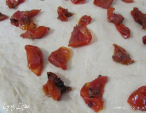 Вяленые помидоры порезать на кусочки и выложить на тесто.