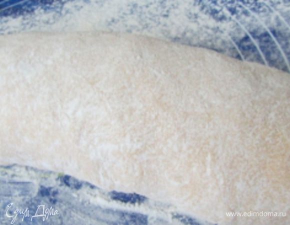 На стол насыпать муку и прокатать по ней рулет, слегка его вытягивая, придавая форму батона.