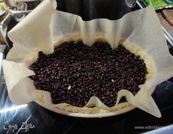 Охлажденное тесто разделите на две части и раскатайте в пласты по форме.
Форму для выпечки смажьте растительным маслом, выложите один пласт теста, сформовав бортики. Наколите вилкой в нескольких местах. Положите на тесто пекарскую бумагу и насыпьте фасоль. Пеките 10 минут в разогретой до 180 градусов духовке, затем уберите фасоль и фольгу и запекайте еще 10 минут.