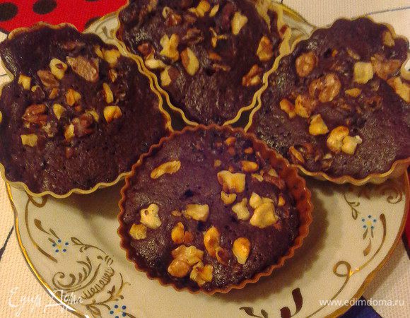 Смешать сахар, просеянную муку, какао, разрыхлитель и влить молоко. Тесто должно получиться жидким (густоту регулировать добавлением молока или муки по необходимости). Распределить по порционным формам (у меня силиконовые), присыпать рублеными орешками, поместить в микроволновку на 3-4 минуты при максимальной мощности.