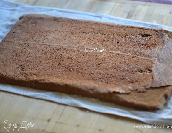 Приготовить легкое полотенце, посыпать сахарной пудрой, для того чтоб бисквит не прилип. Выложить готовый бисквит сразу после духовки на полотенце.