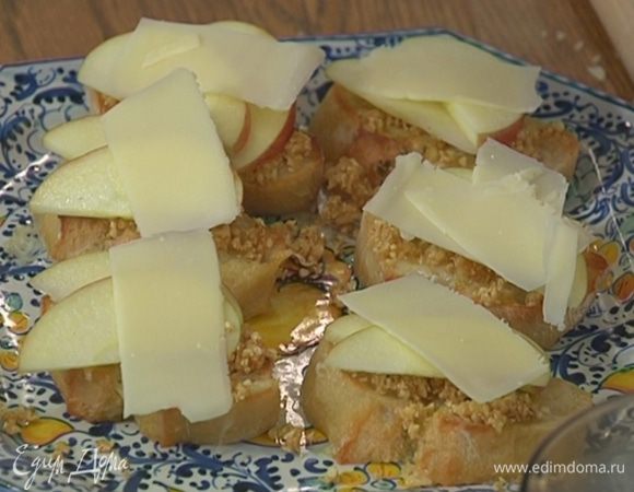 Горячую брускетту смазать орехово-инжирной пастой, на каждый кусочек выложить по паре долек яблока, а сверху — ломтик сыра.