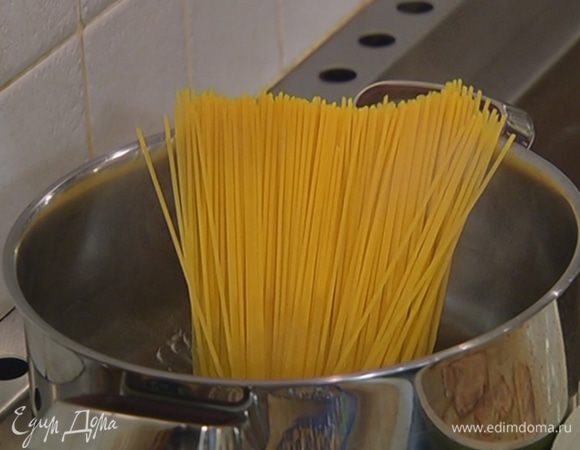 Спагетти целиком опустить в кипящую соленую воду и варить на 1–2 минуты меньше, чем указано в инструкции на упаковке, затем воду слить и сохранить.