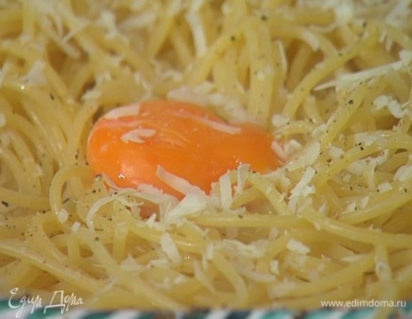 Большую часть молотого перца насыпать на дно глубокой посуды, отправить туда горячие спагетти, добавить 1 желток пашот, большую часть натертого сыра, влить немного воды, в которой варились макароны, и все перемешать.