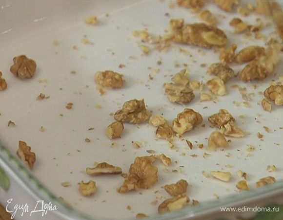 Грецкие орехи слегка поломать руками и равномерно высыпать на дно жаропрочной формы.