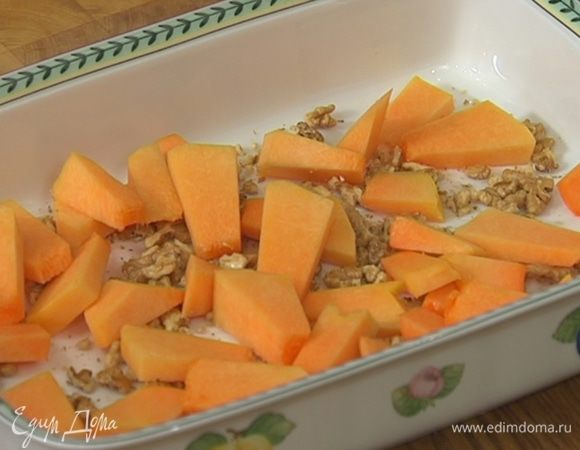 Тыкву почистить, нарезать небольшими кусочками и выложить в форму на орехи.