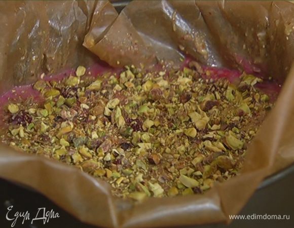 Оставшиеся фисташки измельчить в ступке, так чтобы остались небольшие кусочки, и посыпать тесто.