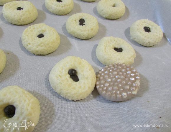 Каждый шарик придавила фигурной пуговицей. В серединку кладем 1-2 шоколадных капли. Отправить в разогретую духовку (150 градусов). Выпекать в течение 15-20 минут до золотистого цвета.