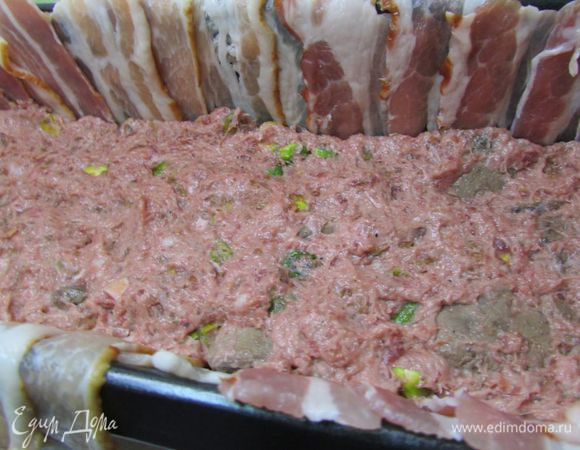 На бекон выложить третью часть фарша. Фарш плотно утрамбовать. 