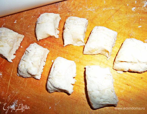 Через час делим тесто примерно на три части. Берём первую, вытягиваем в колбаску и делим на кусочки.