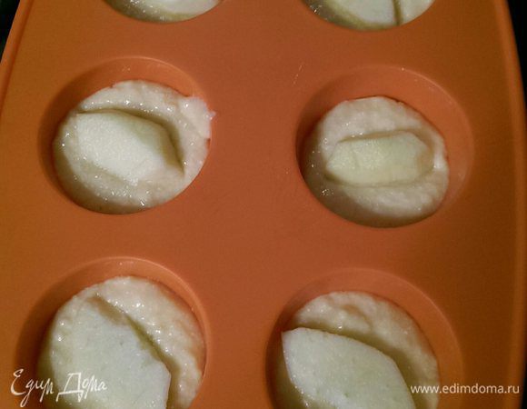 Муку смешать с разрыхлителем, перемешать с яичной смесью и добавить туда лимон.

Аккуратно перемешать. Полученную смесь разложить по формочкам. Чуть меньше половины.

Далее в каждую формочку положить по куску яблока. Я резала дольки поперек, предварительно очистив от шкуры и семечек, но все зависит от размера формочек.