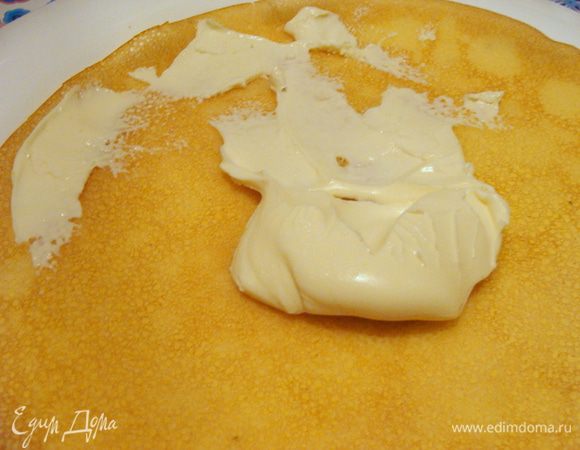 На первый блинчик намазать плавленый сыр.