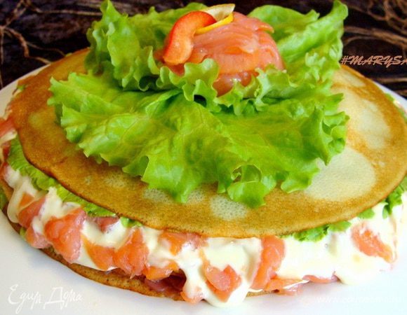 Можно оставить получившийся тортик так, накрыв пищевой пленкой до подачи на стол. Я придавила его сверху тарелкой и подержала некоторое время под гнетом, чтобы торт был более плотным.
Сыр застывает довольно быстро.
Сверху украсила листиками салата и розочкой из форели.