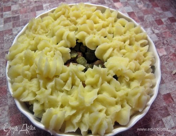 Сверху из корнетика отсадить розочки из пюре, оставив немного места в серединке. В середину аккуратно, чтобы не повредить желток, выбить яйцо.
Слегка сбрызнуть растительным маслом и поставить запекаться в духовку до готовности яйца.
