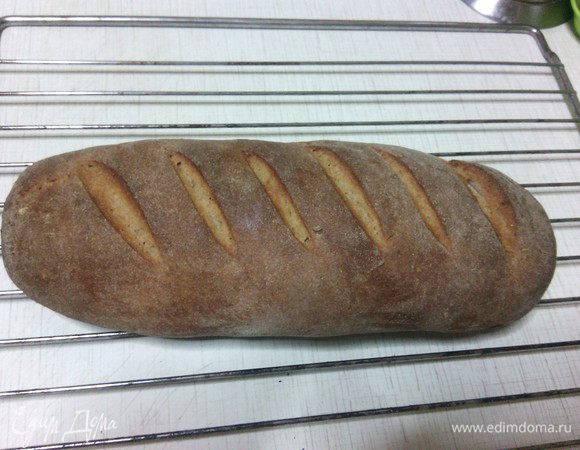 Вынуть хлеб из духовки, снова сбрызнуть водой и оставить остывать на решётке прикрыв полотенцем. 