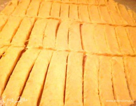 Разделить тесто пополам и 1 часть раскатать на припыленном мукой листе пергамента. Разрезать на полоски шириной примерно 1 см и длиной 5-7 см.
