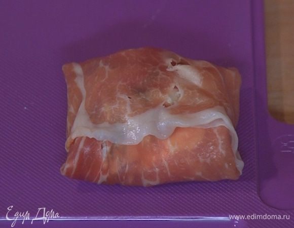 На край каждого ломтика ветчины выложить по 1 ст. ложке феты с финиками и свернуть конвертиками, чтобы вся начинка оказалась внутри.