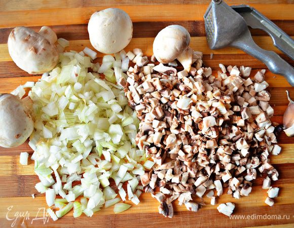 Измельчите лук, очистите и порежьте грибы, с помощью пресса измельчите чеснок.