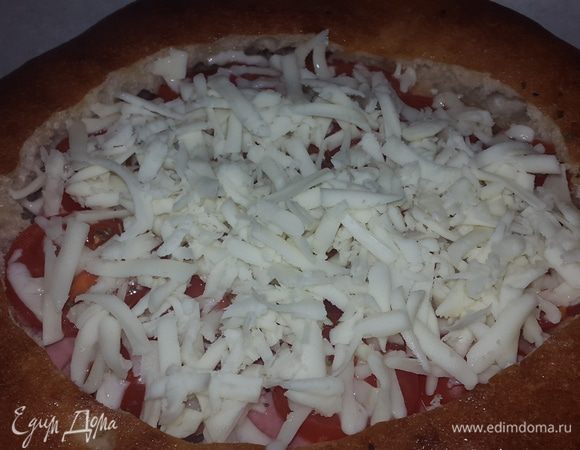 Когда лепешка и начинка прогрелись, я достала противень, посыпала лепешку натертым на крупной терке сыром и снова отправила в духовку, на верхний уровень.