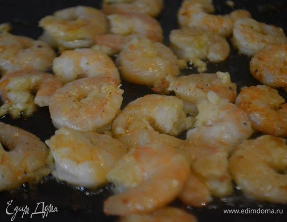 Зажарить креветки на сковороде до легкого розового цвета. Добавить рубленный чеснок и обжарить еще 30 секунд.