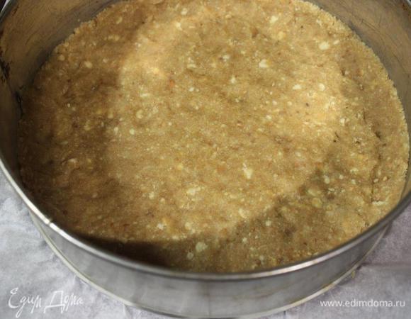 Выкладываем получившееся "тесто" в разъемную форму, дно которой застелено пергаментом, и утрамбовываем. Бортики формируем по желанию. 
У меня форма 21 см, мне показалось, что по высоте чиз получился идеальным, но можно брать форму и меньше.
Ставим форму в холодильник, а сами занимаемся сырным слоем.