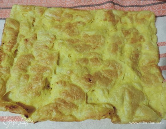 Выпекаем коржи в разогретой до 200°C духовке примерно 10–12 минут. Готовый корж сразу снимаем с бумаги и перекладываем на чистое сухое полотенце. Аналогично выпекаем второй корж.