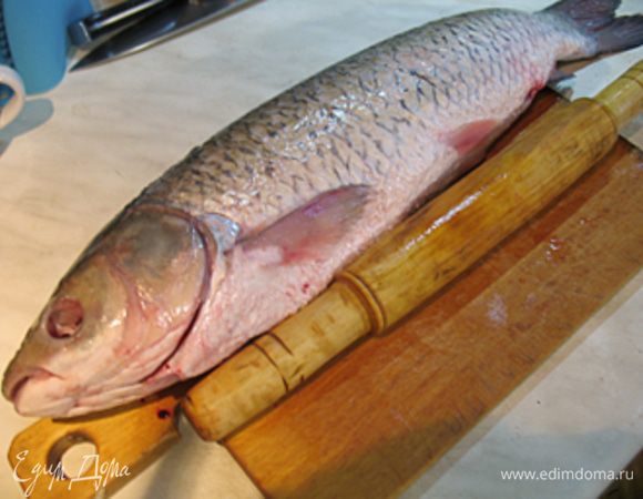 Подготовка рыбы. Очистить рыбу от чешуи. Удобнее всего рыбу чистить в большой миске с водой.
Кладем рыбу брюшком к себе и очищаем от внутренностей и жабр.
Чтобы легко извлечь внутренности рыбы, с начала надо освободить самую длинную кишку, для чего делаем поперечный надрез у хвостового плавника длиной 1 см. 
Переходим к освобождению внутренностей у головы. Раскрываем жаберную коробочку и подрезаем ножницами жабры сначала у основания головы, переходя к нижней части и удаляем жабры. Подрезаем пищевод, так как он очень плотный. Аккуратно вытаскиваем внутренности, главное не порвать желчный пузырь.
Плавники оставляем, они помогут проверить рыбу на готовность. По желанию отстригаем хвост.
Удаляем у рыбы глаза, они могут дать горечь.

Чтобы легче снять кожу с рыбы ее нужно легонько отбить скалкой, с каждой стороны нам необходимо сделать 8-10 ударов. При ударах скалкой мышцы у рыбы станут слабее, мясо не так сильно будет прикреплено к коже, это позволит снять кожу намного легче, чем до этого.