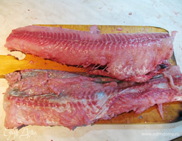 Отрезаем голову по жаберной коробочке, хребет перерезаем ножницами.
Кладем рыбу брюшком к себе. По кругу аккуратно подрезаем кожицу, и, подтягивая, срезаем ее. Выворачиваем ее наизнанку до хвоста, там, где плавники глубоко по мясу подрезаем ножницами. Отрезаем хребет у хвоста. 
Я предпочитаю снимать кожицу пальцами, подрезая ножницами по хребту, в районах плавников.
У нас получился чулок, на нем остается мясо. Берем ложку и аккуратно соскребаем мясо с чулка. Готовый чулок солим, перчим и выворачиваем на лицо.
Снимаем мясо с крупных костей.