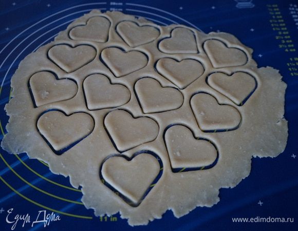 Включить разогреваться духовку до 180 градусов.
Для удобства раскатывания, тесто лучше разделить на 2 части. Одну часть пока вернём в холодильник. А с другой будем работать. Охлаждённое тесто раскатать. Выемкой для печенья вырезать сердечки чётное количество штук.