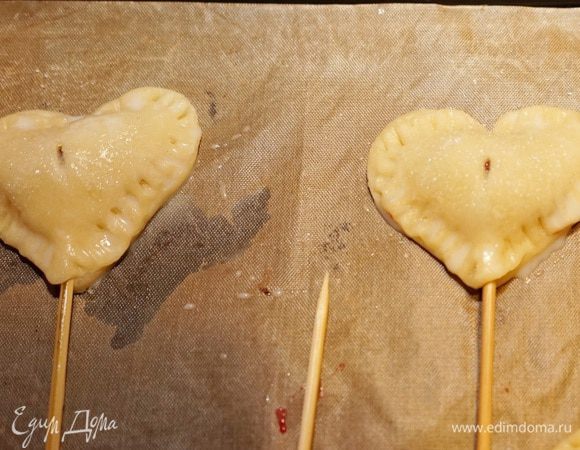 Заклеить пирожки. Края хорошо придавить вилкой. Смазать пирожки сверху яичной смесью и посыпать сахаром.	
Такие пирожки можно подать и на шпажках. Для этого шпажки надо замочить минут на 20 в воде и затем вложить внутрь пирожка.