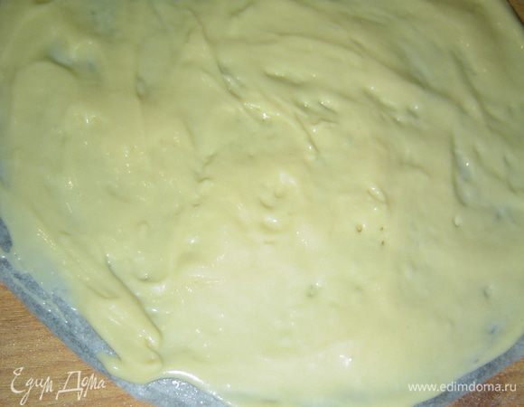 Тесто готово и мы приступаем к выпечке коржей. Тесто разделяем на 5 частей. Я взяла низ от разъемной формы 24 см в диаметре, накрыла его пергаментом, смазала слегка растительным маслом. Сверху выкладываем одну часть теста и, смоченными в воде руками, распределяем равномерно по всей поверхности.