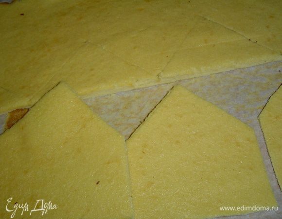 Корж необходимо разрезать вдоль на две равные части, аккуратно выровнять края. Можно приступать в вырезанию домиков для короны. 