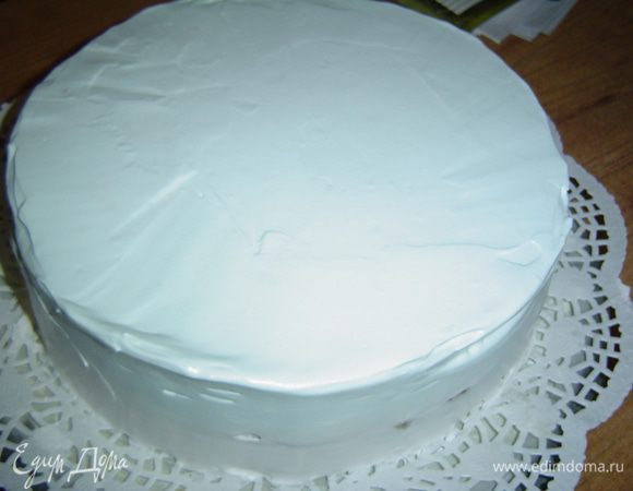 Взбиваем сливки с сахарной пудрой до устойчивых пиков, добавляем черничный джем и перемешиваем. В результате получаем нежный голубой цвет. Эти сливки наносим на бока и верх торта, ровняем.